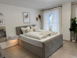 ein großes Bett in einem Zimmer mit Fenster in der Unterkunft Ferienwohnung Alpenperle in Immenstadt im Allgäu