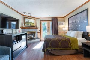 une chambre d'hôtel avec un lit et une cheminée dans l'établissement Super 8 by Wyndham Gananoque - Country Squire Resort, à Gananoque 81 autres photos