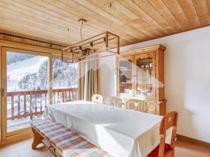 a dining room with a table and a large window at Appartement duplex lumineux, 4 pièces, 6 pers, Méribel centre, pistes et commerces à proximité - FR-1-411-736 in Les Allues