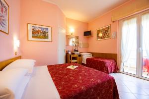 a hotel room with two beds and a toilet at Hotel Driade sul mare in Rimini