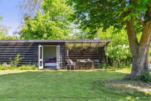 eine Blockhütte mit einem Tisch und Stühlen im Hof in der Unterkunft Smukt Familiesommerhus I Vejby in Vejby Strand