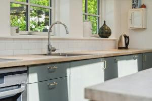 eine Küche mit blauen Schränken und einer Spüle in der Unterkunft Smukt Familiesommerhus I Vejby in Vejby Strand