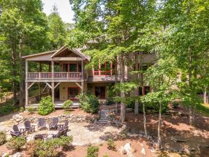 a house with a deck and chairs in the yard at Fern Ridge Lodge at Sweetgrass in Blowing Rock