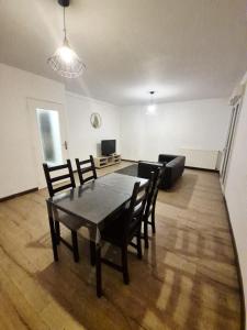 a living room with a table and chairs and a couch at Le Coty duplex - 5min chantier et 250m plage in Saint-Nazaire +3 photos