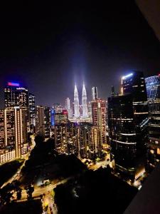 eine Skyline der Stadt bei Nacht mit hohen Gebäuden in der Unterkunft Panorama luxury Suites At TM Persiaran Stonor KLCC in Kuala Lumpur