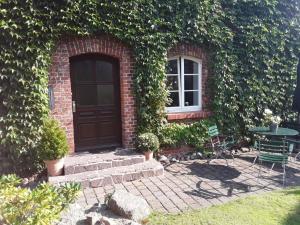 ein Backsteinhaus mit einer schwarzen Tür und einem Fenster in der Unterkunft Marie Luise in Ferchesar