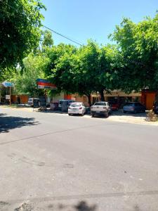 a street with cars parked in front of a gas station at La casa de las flores in Las Heras