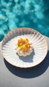 a plate of food on a table next to a pool at Hôtel La Villa Douce in Rayol-Canadel-sur-Mer