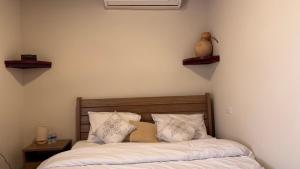 un dormitorio con una cama con sábanas y almohadas blancas en Marsa wadi shab, en Ash Shāb
