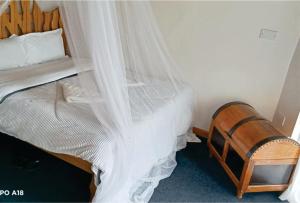 a bedroom with a bed with a white canopy at Hotel White Sandcastle Mara Lodge in Sekenani