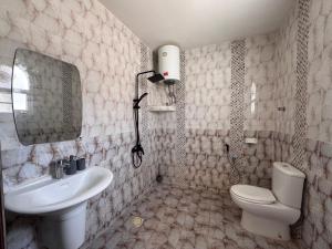 Un baño blanco con lavabo e inodoro. en Marsa wadi shab, en Ash Shāb