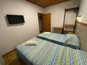 two beds in a room with two towels on them at Venere - Bed and Breakfast in Florianópolis