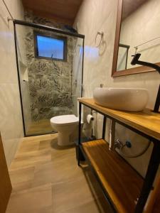 a bathroom with a shower and a toilet and a sink at Venere - Bed and Breakfast in Florianópolis