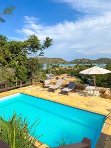 a swimming pool with a view of the water at Pousada Encanto de Búzios in Búzios