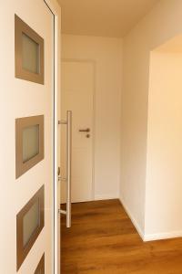 an empty room with a door and wooden floors at Ferienwohnung Las Vegas in Marienheide
