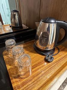 Ein Teekessel und Weingläser auf einer Theke in der Unterkunft فندق قصر ماريوت 1 in Al ‘Azīzīyah