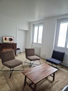 a room with three chairs and a coffee table at Appart 4 chambres Idéal travailleurs et familles in Saint-Nazaire