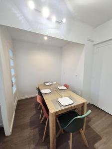 a dining room with a wooden table and chairs at Appart 4 chambres Idéal travailleurs et familles in Saint-Nazaire +26 photos