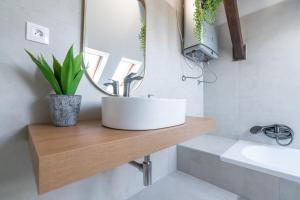 un bagno con un lavandino bianco e uno specchio di B-Home Apartments - Štýlový podkrovný apartmán 74 m2 a Trenčín Altre 6 foto