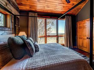 a bedroom with a bed and a large window at Owls Nest in Seven Devils