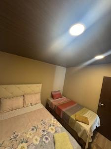 a small bedroom with two beds and a light at Mar Adentro Casa 5 in Santa Cruz de la Sierra