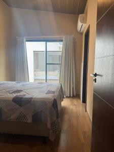 a bedroom with a bed and a large window at Mar Adentro Casa 5 in Santa Cruz de la Sierra