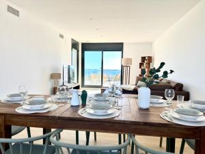 a dining room table with plates and glasses on it at Les Flors de Cunit Villa Cedra in Cunit