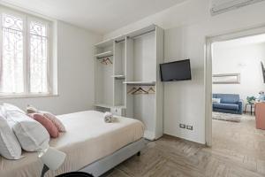 um quarto branco com uma cama e uma tv em Milano Malpensa 2 min - Suite With Wifi, AC, Free Park em Cardano al Campo