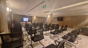 ein Konferenzraum mit schwarzen Stühlen und einem Fernseher in der Unterkunft Tulip Plaza By LPC Hotels & Resorts in Hafar Al-Batin