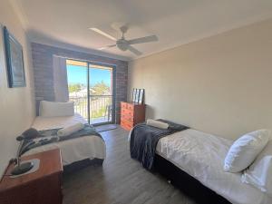 a bedroom with two beds and a ceiling fan at Seamist unit in Nambucca Heads