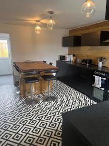 a kitchen with a wooden table and stools at Highland Park Cottage in Kirkwall