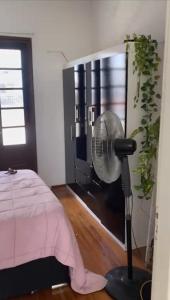 a bedroom with a pink bed and a fan at Apartamento entero 2 Dormitorios in Montevideo