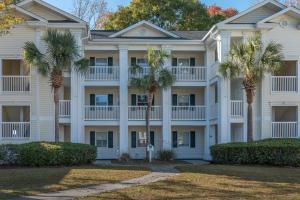 un grande edificio bianco con palme di fronte di Charming Golf Getaway! River Oaks 19E a Myrtle Beach