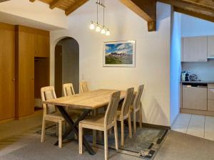 a kitchen and dining room with a wooden table and chairs at Chasa Sot-Chaunt 301 in Samnaun +23 photos