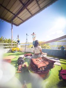 The Rawscape hostel في كاوساني: امرأة تجلس على الأرض في الفناء