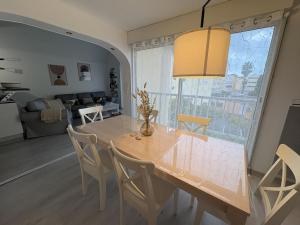 a dining room table with chairs and a large window at Spacieux duplex sur le port in Gruissan +7 photos