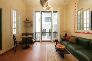 ein Wohnzimmer mit einer grünen Couch und einem Tisch in der Unterkunft Lebatriu in Hanoi