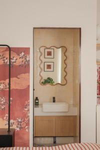 ein Badezimmer mit Waschbecken und Spiegel an der Wand in der Unterkunft Lebatriu in Hanoi + 48 Fotos