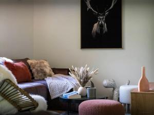 a living room with a couch and a deer head on the wall at Chalet Ormiages - OVO Network in Saint-Gervais-les-Bains