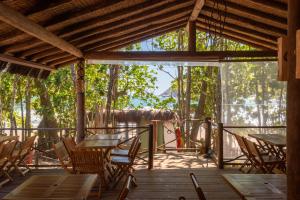 a room with tables and chairs on a wooden deck at Pousada Canto Bravo in Ilhabela +78 photos