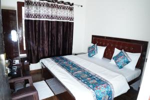 une chambre avec un grand lit avec un rideau dans l'établissement Sukoon Inn Hotel & Restaurant, à Someshwar