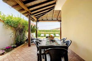 une table noire et des chaises sur une terrasse dans l'établissement Villa Leo, à Terracine