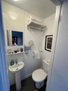 a white bathroom with a toilet and a sink at Skyline Guesthouse Newquay in Newquay +62 photos