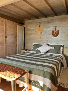 - une chambre avec un grand lit et un mur en bois dans l'établissement Bed0Bled Cabanes & Holiday homes, à Sidi Kaouki