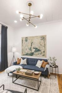 Una sala de estar con un sofá azul y una mesa. en Lafayette Getaway-Downtown House with Free Parking, en Lafayette