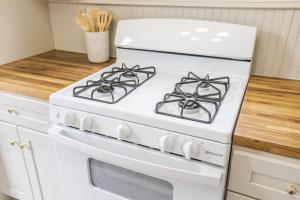La cocina está equipada con fogones blancos. en Lafayette Getaway-Downtown House with Free Parking, en Lafayette