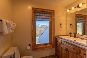a bathroom with a toilet sink and a window at Mio Nido at Eagles Nest in Newland