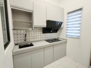 Private Roomstay Shared Home Near KTM Batu Gajah في باتو جاجاه: مطبخ أبيض مع حوض وموقد