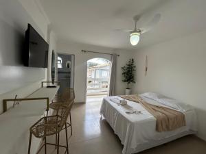 1 dormitorio con 1 cama, sillas y TV en Pousada do Moinho, en Cabo Frío 79 fotos más