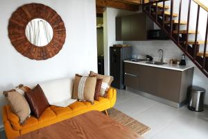 Una sala de estar con un sofá amarillo y una cocina. en Vive Bayahibe a Pasos de la Playa by Caribbean Paradise Rentals, en Bayahibe